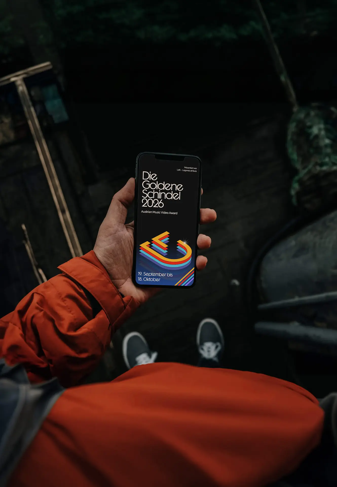 The 2026 website on a phone, held in a hand
